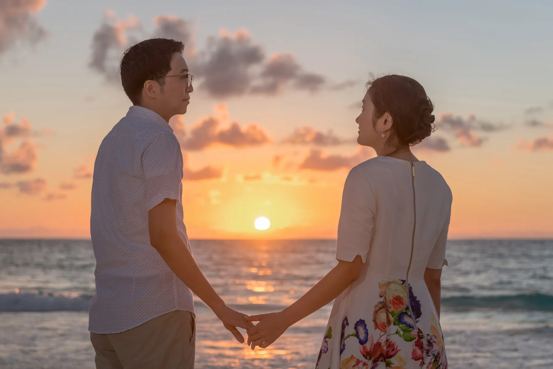 Honeymoon couple holding hands at sunrise on a Cancun beach