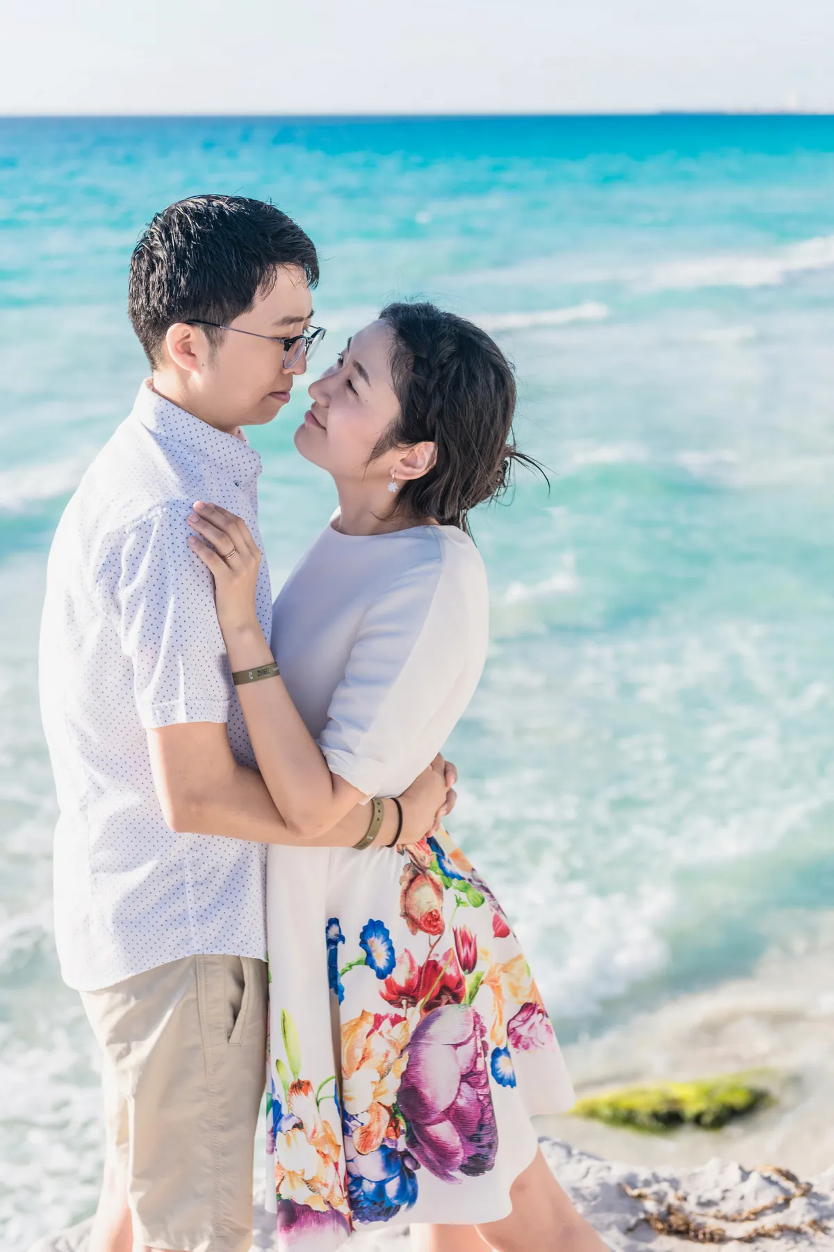 Couple embracing in front of emerald Caribbean water