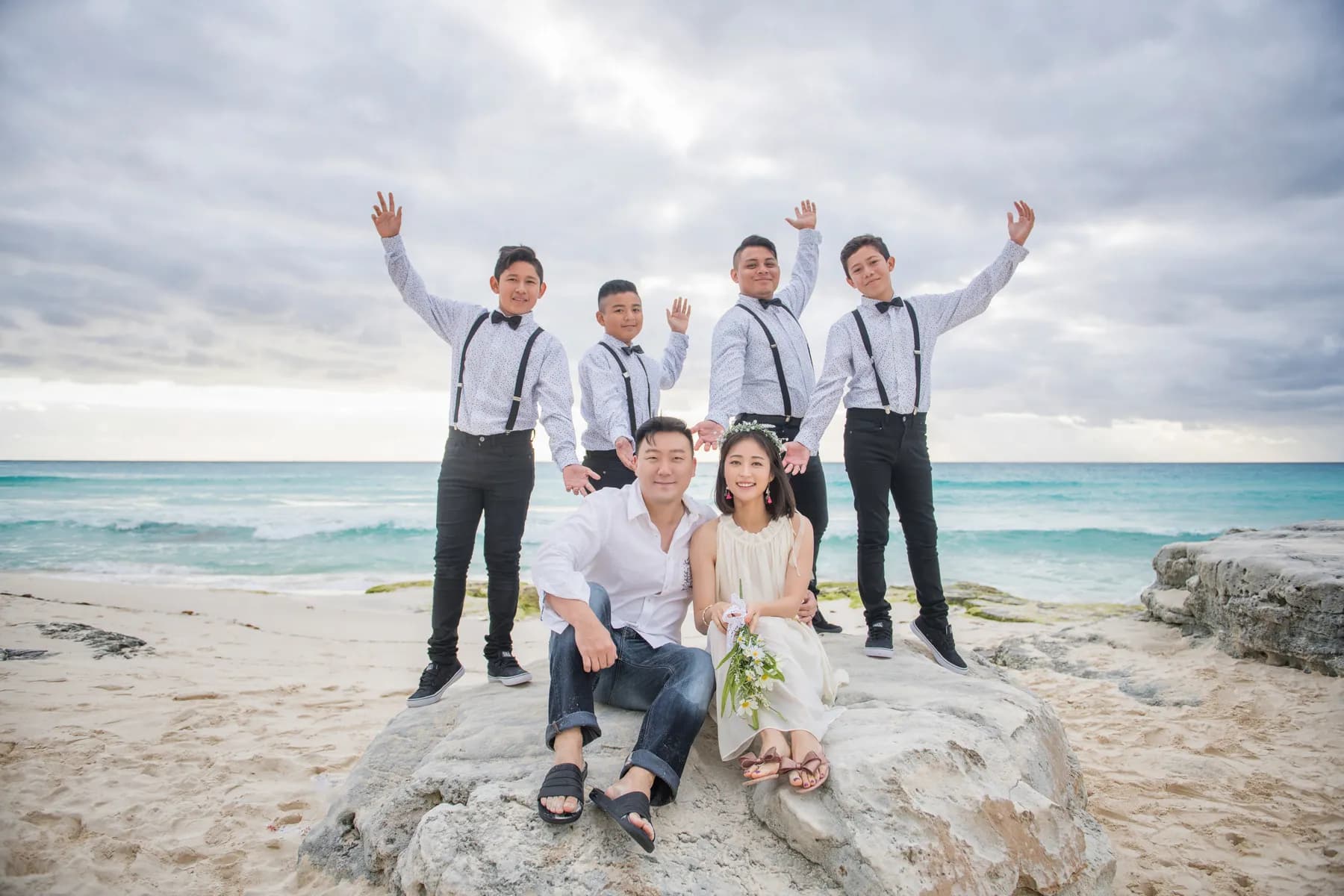 Newlyweds and friends celebrating together on a Cancun beach