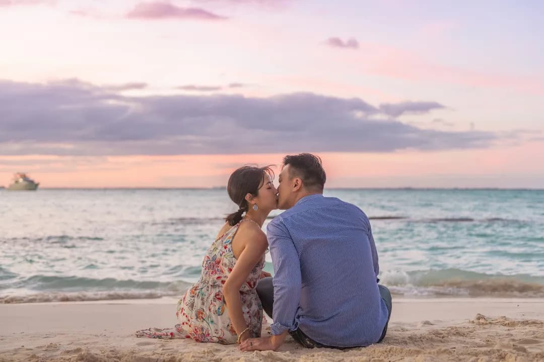Couple sitting and kissing on the beach at sunset on Isla Mujeres